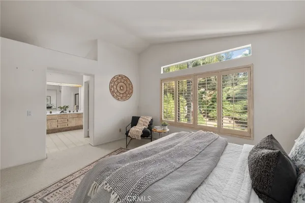 a bedroom with a bed and a large mirror