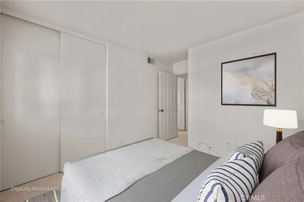 a bedroom with a bed and a painting on the wall