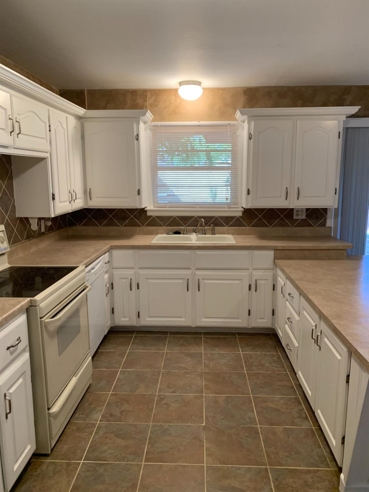 2812 56th Street Lubbock, TX 79413 - Photo 3 of 14 a kitchen with a sink a stove and cabinets