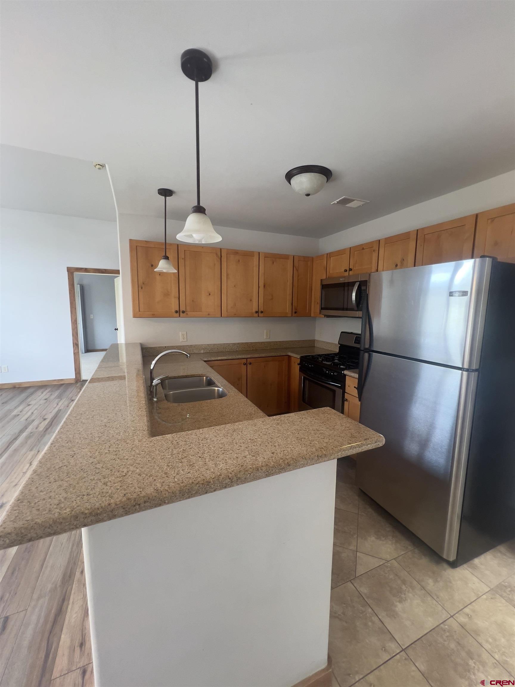 540 Redcliff Circle, Unit E 203 Ridgway, CO 81432 - Photo 8 of 36 a kitchen with stainless steel appliances granite countertop a sink a refrigerator and a stove