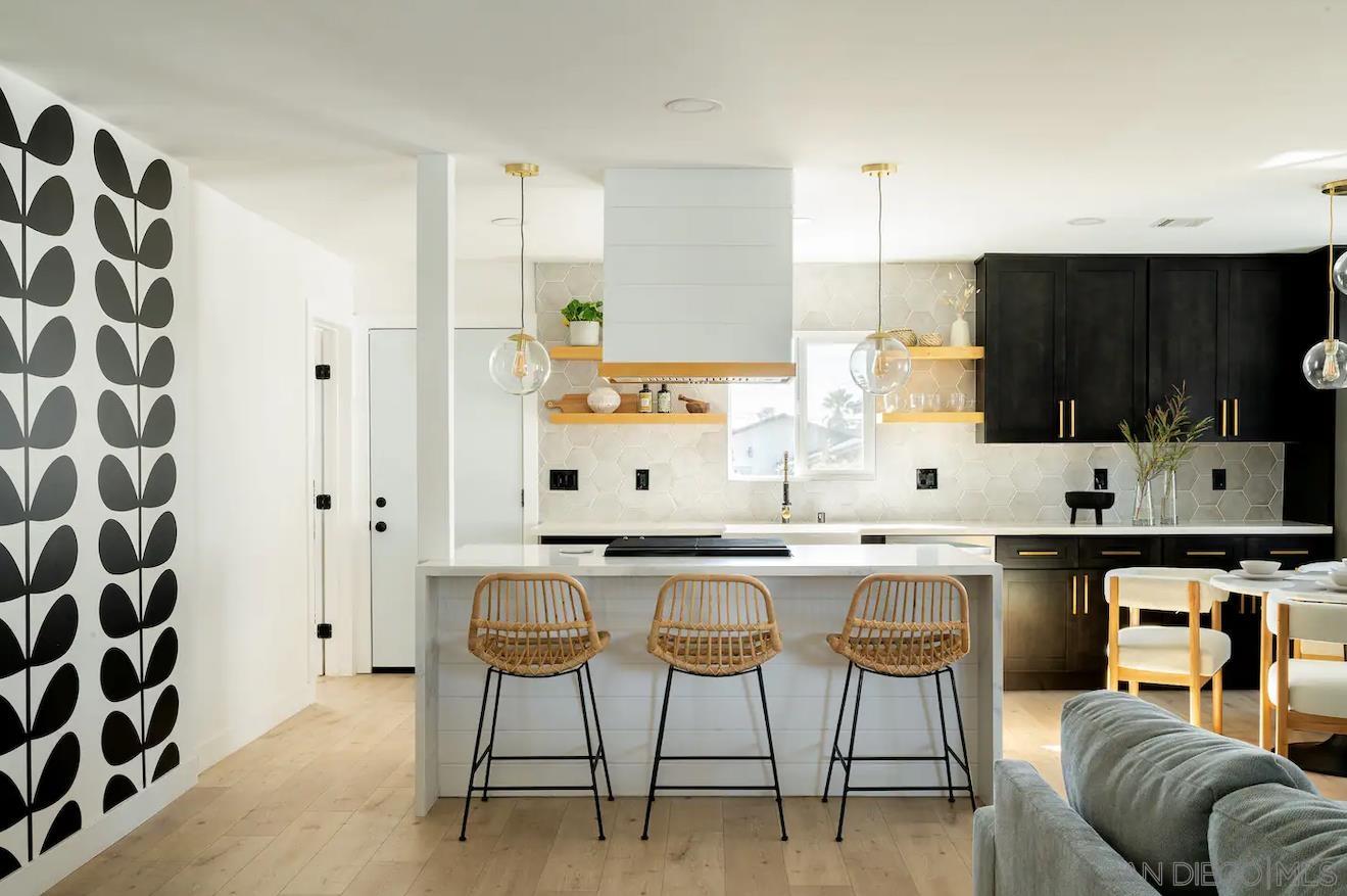 a kitchen with stainless steel appliances a table and chairs in it