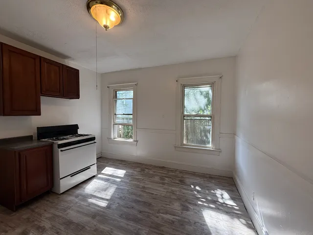 a kitchen with granite countertop stainless steel appliances a stove and a large window