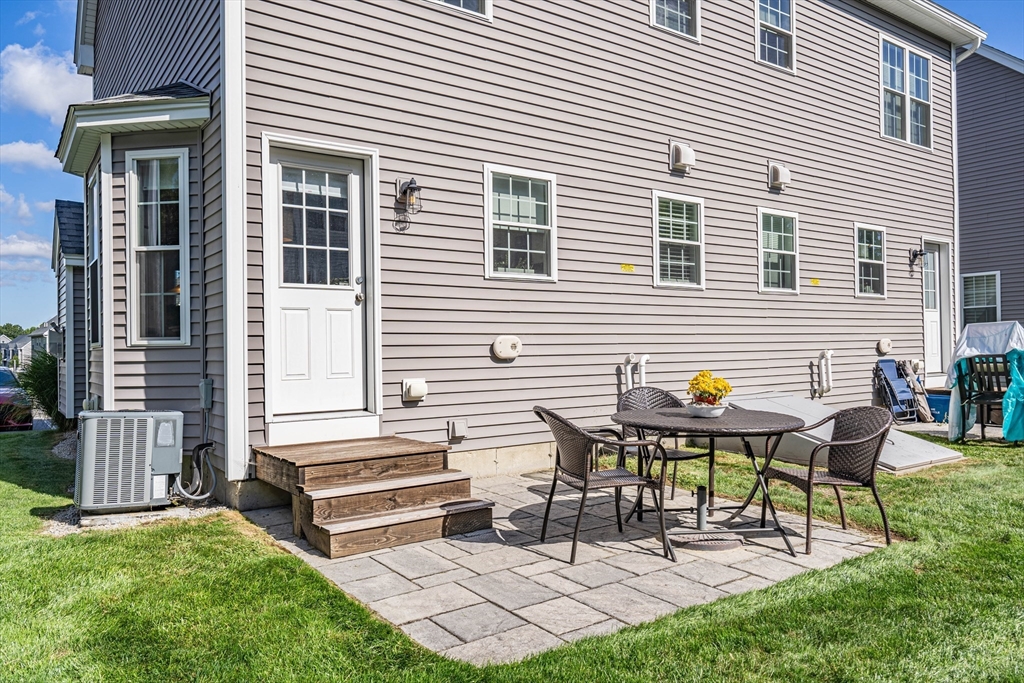 5 Riley Road, Unit 5 Tyngsboro, MA 01879 - Photo 2 of 4 a view of a chairs and table in back yard of the house