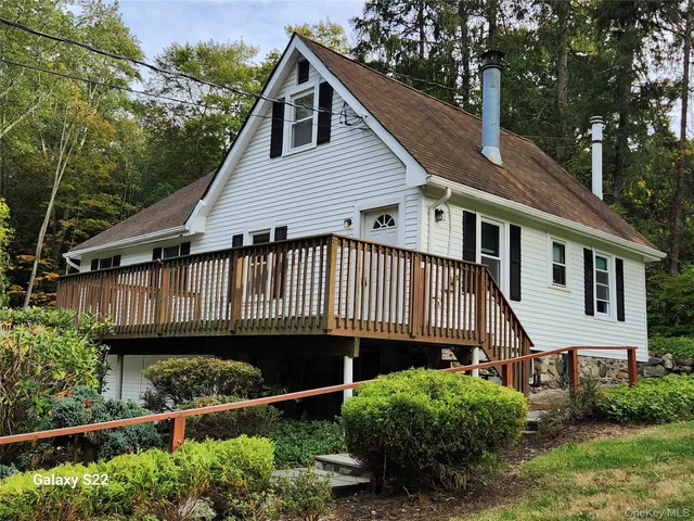 a view of a house with wooden deck front of house