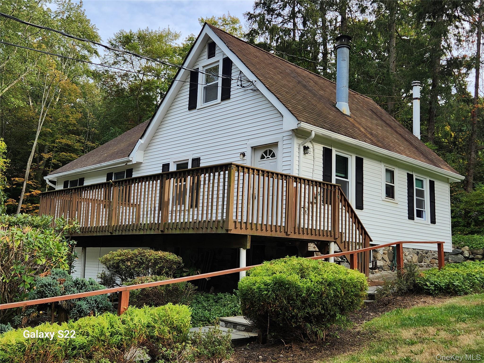 a view of a house with wooden deck front of house