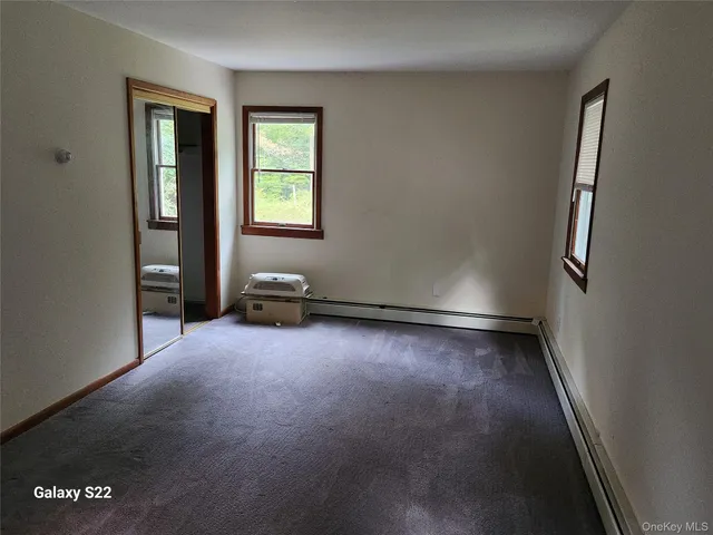 a room with chairs and two windows