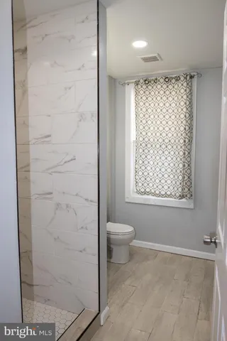 a bathroom with a toilet sink vanity and mirror