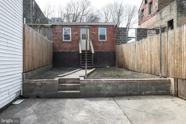 a view of house with stairs and wooden fence