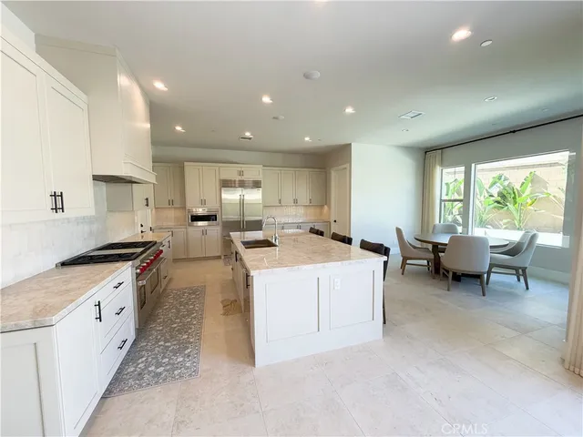 a large kitchen with stainless steel appliances granite countertop a lot of counter space and a sink