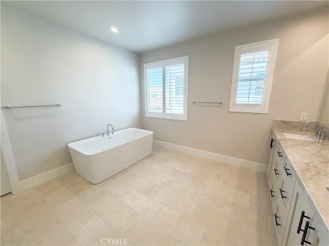 a bathroom with a tub sink and mirror