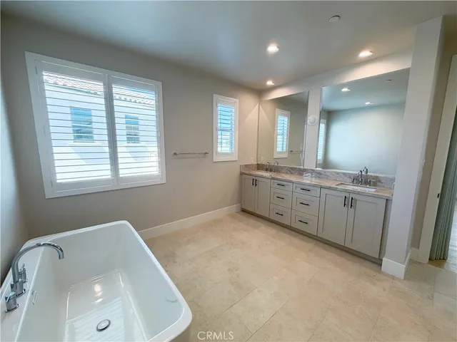 a bathroom with a granite countertop sink mirror and a bathtub