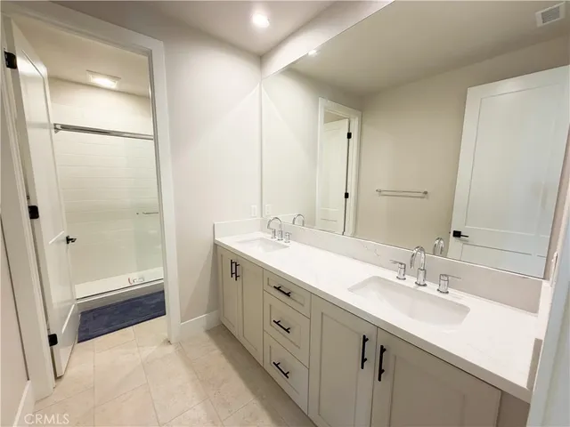 a spacious bathroom with a shower sink and a mirror