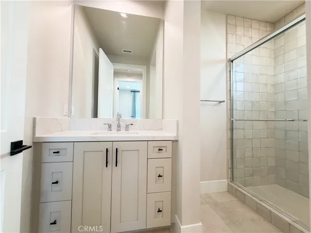 a bathroom with a shower sink and mirror