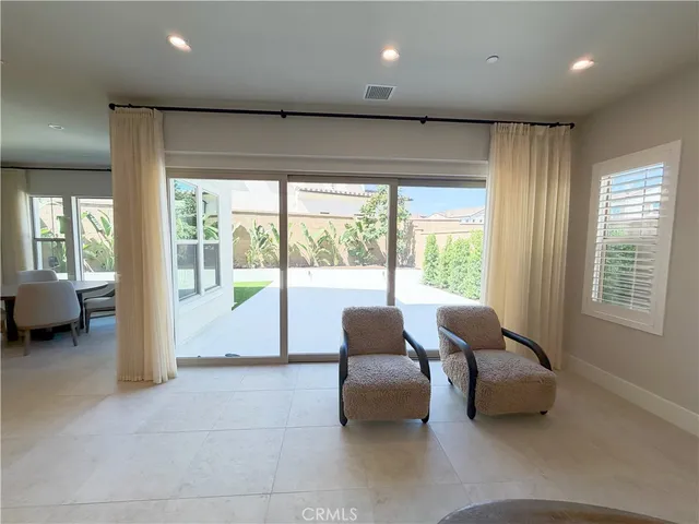 a living room with furniture and a floor to ceiling window