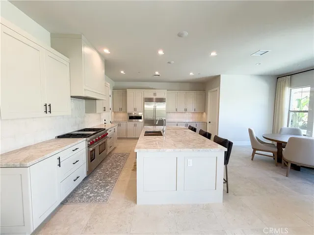 a large kitchen with stainless steel appliances kitchen island granite countertop a sink and cabinets