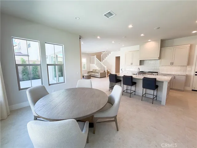 a living room with stainless steel appliances furniture a dining table and chairs