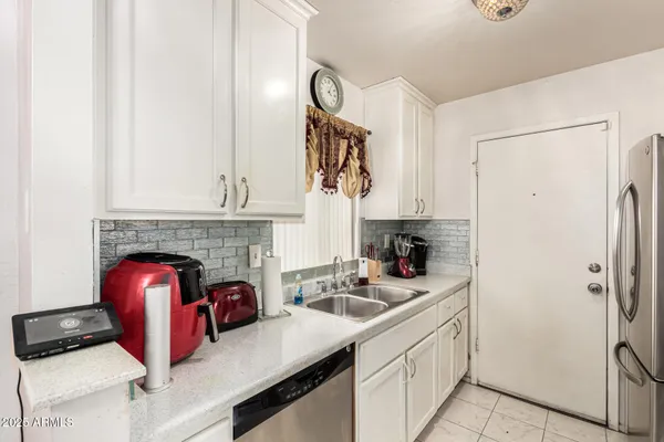 a kitchen with stainless steel appliances a sink cabinets and a fireplace
