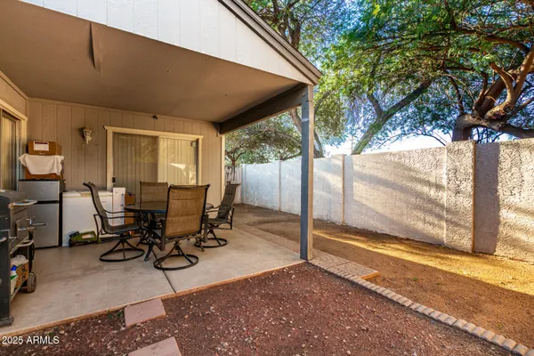 a view of a patio with table and chairs and floor to ceiling window