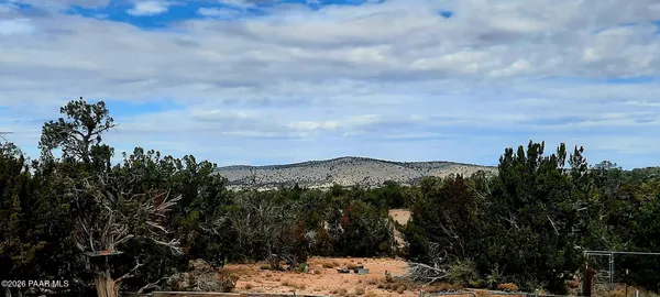 a kitchen with granite countertop a refrigerator a stove a sink dishwasher and wooden cabinets with wooden floor