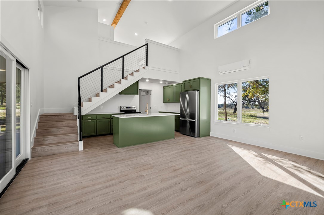 7660 McGregor Park Road Temple, TX 76502 - Photo 23 of 47 a view of a kitchen with wooden floor electronic appliances and stairs