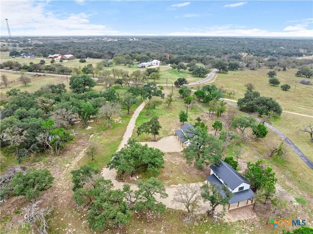 an aerial view of residential houses with outdoor space and trees