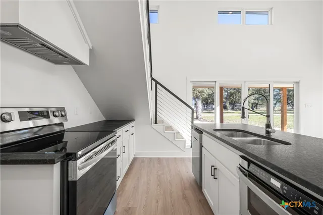 a kitchen with a sink stove and cabinets