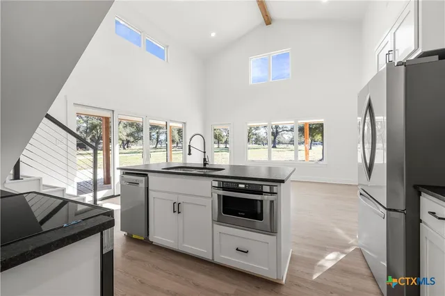 a kitchen with stainless steel appliances granite countertop a stove a sink and a refrigerator