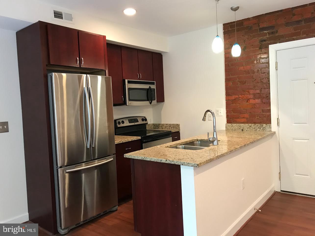 5401-5407 9th Street Northwest, Unit 102 Washington, DC 20011 - Photo 2 of 14 a kitchen with stainless steel appliances granite countertop a refrigerator and a sink