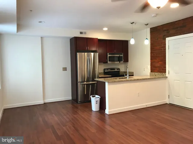 a kitchen with a refrigerator and a stove top oven