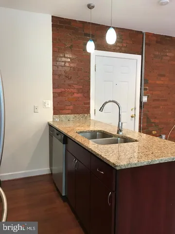 a bathroom with a granite countertop sink a toilet and mirror