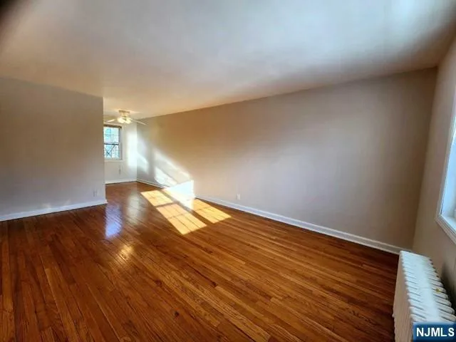 a view of empty room with wooden floor