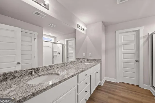 a bathroom with a granite countertop sink and a mirror