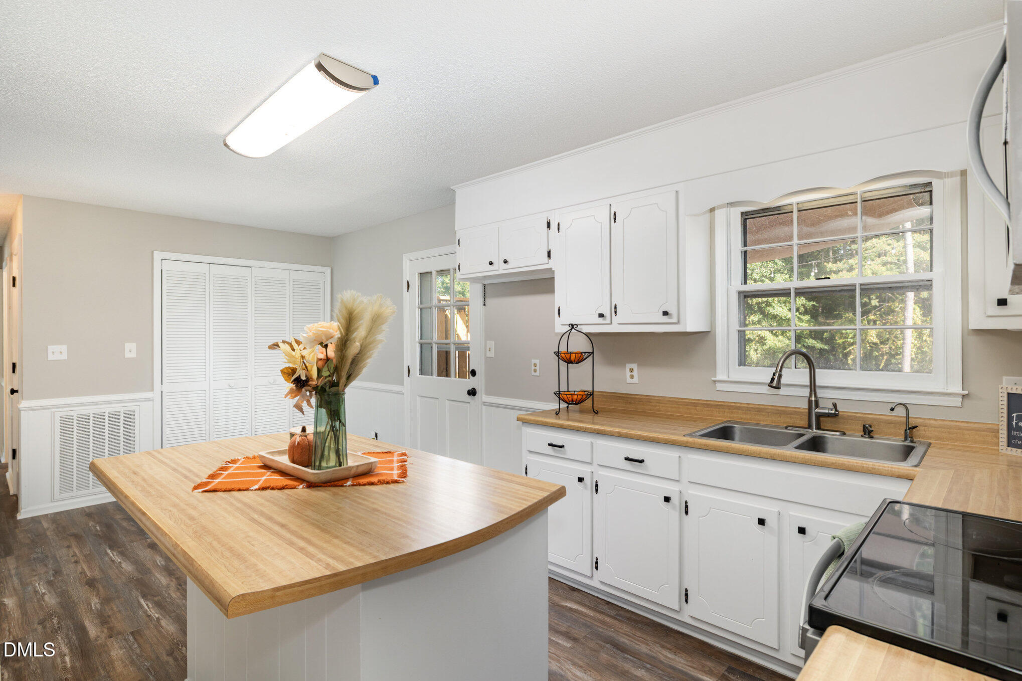 414 Aquilla Road Benson, NC 27504 - Photo 9 of 30 a kitchen with a stove a sink a dining table and chairs