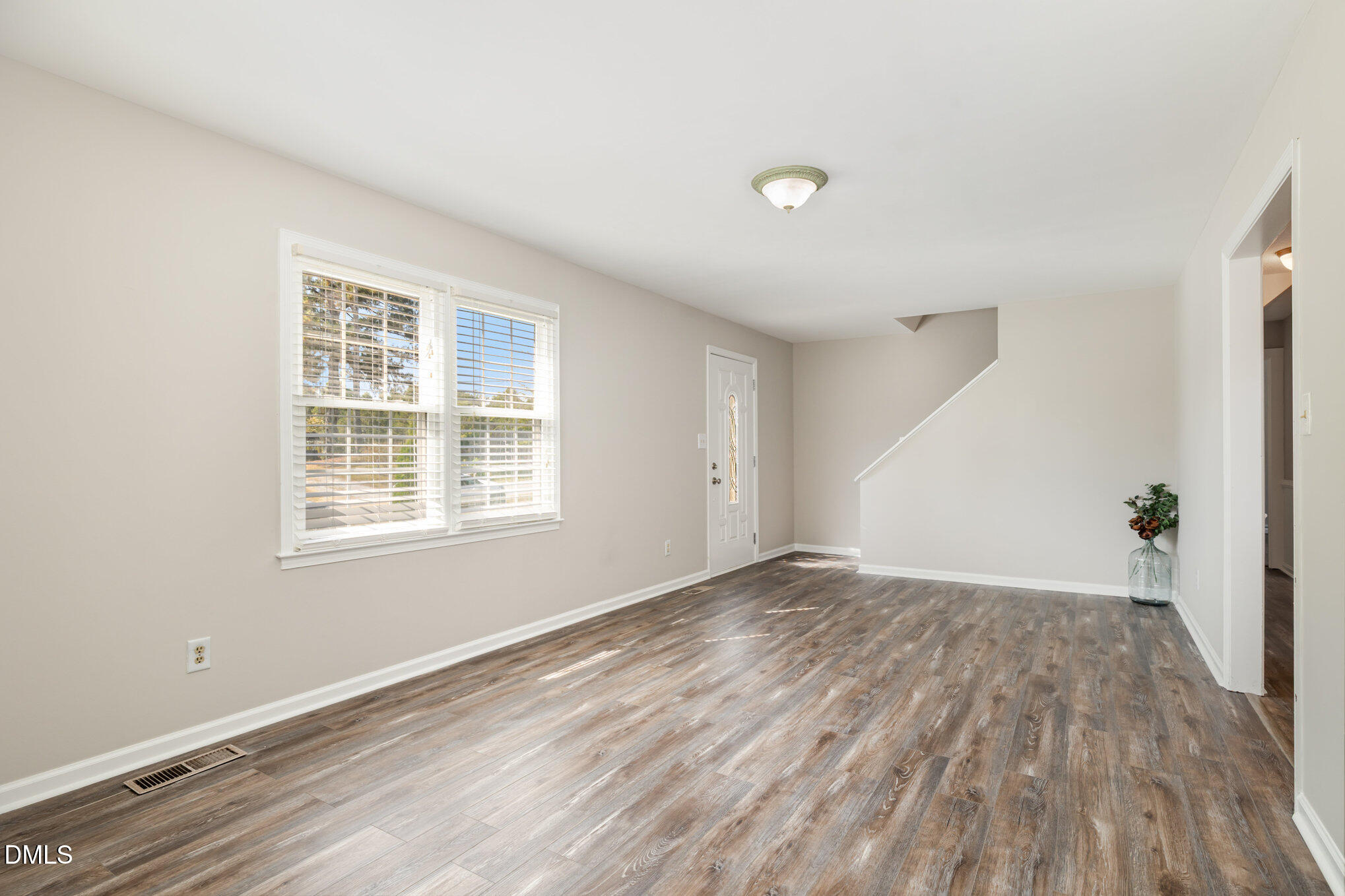 414 Aquilla Road Benson, NC 27504 - Photo 5 of 30 a view of an empty room with wooden floor and a window