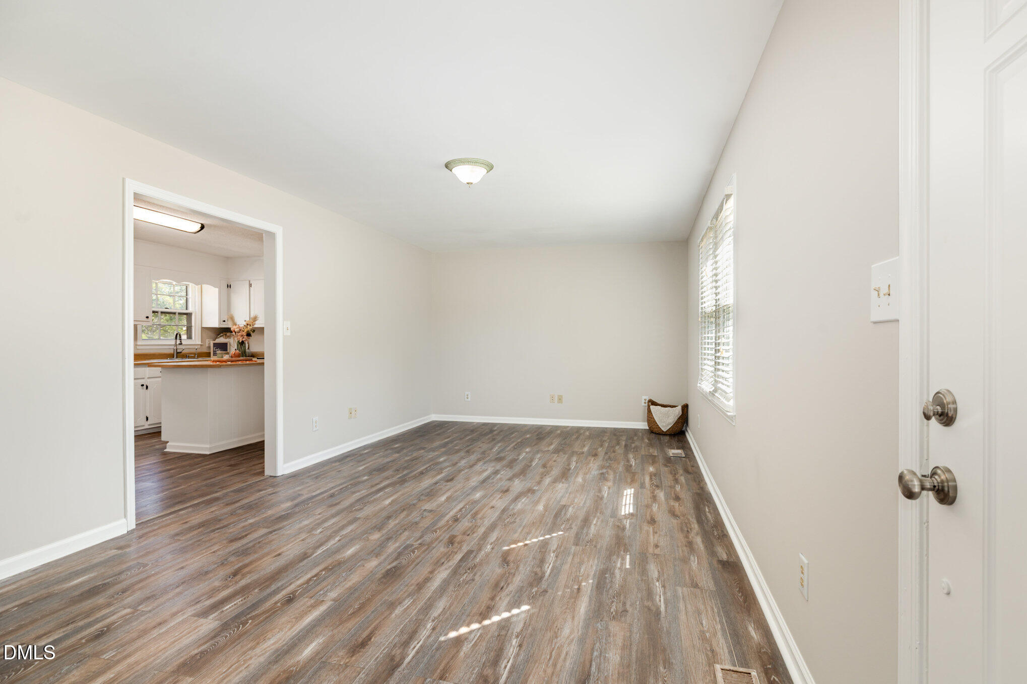 414 Aquilla Road Benson, NC 27504 - Photo 6 of 30 a view of a room with wooden floor and a kitchen