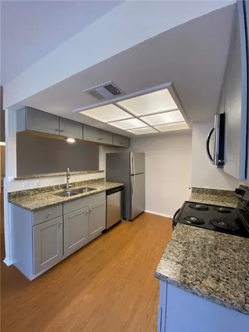 a kitchen with granite countertop a sink and a stove