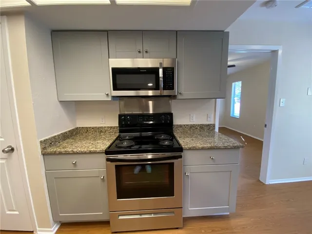 a kitchen with granite countertop stainless steel appliances and white cabinets