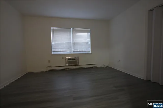 an empty room with wooden floor and a window