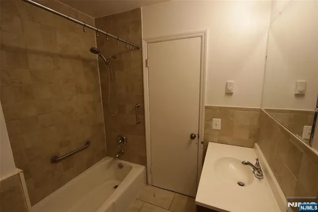 a bathroom with a tub a sink and a shower