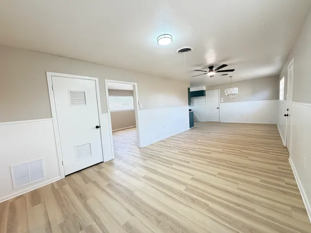 a large kitchen with kitchen island a sink dishwasher a stove and a refrigerator with wooden floor