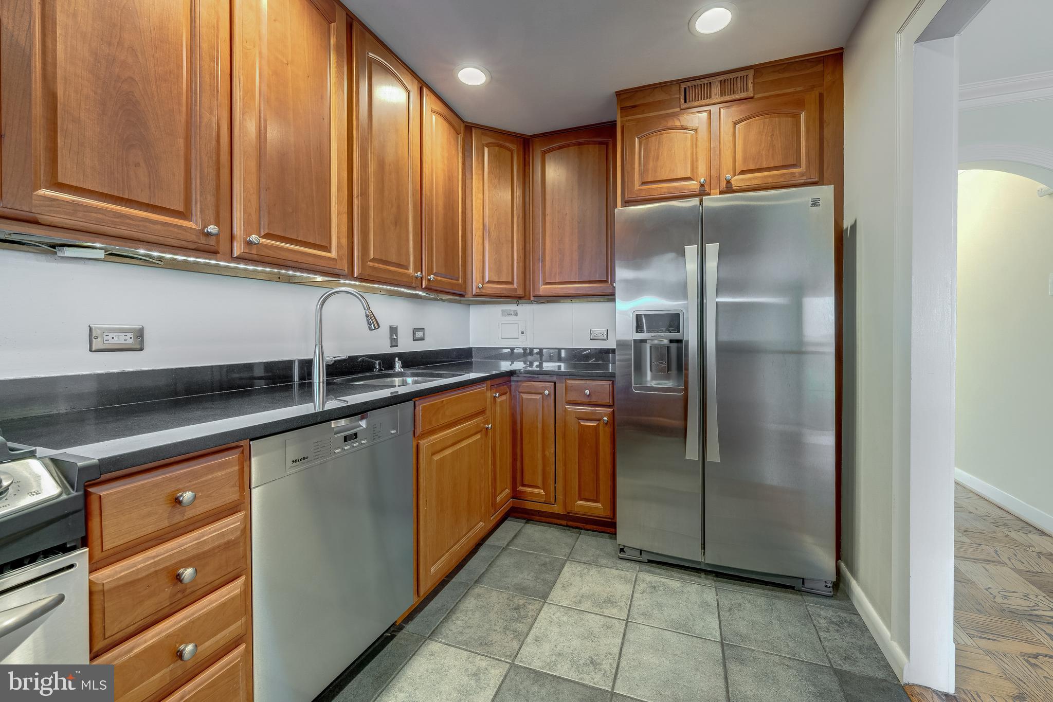 1200 North Nash Street, Unit 549 Arlington, VA 22209 - Photo 26 of 70 a kitchen with stainless steel appliances granite countertop a refrigerator and a sink