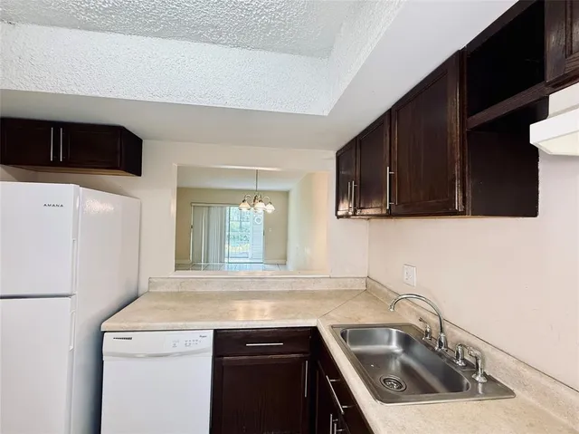 a kitchen with a sink dishwasher and a refrigerator