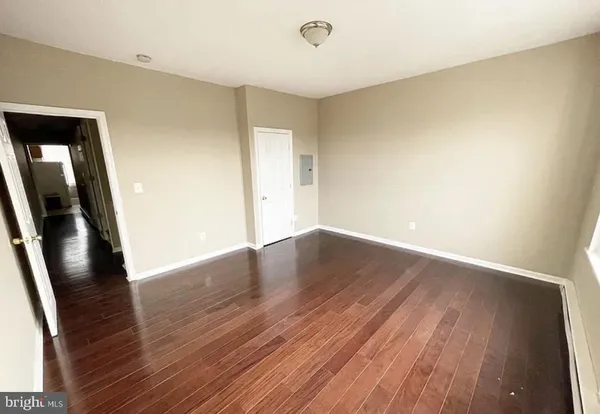 an empty room with wooden floor and entrance