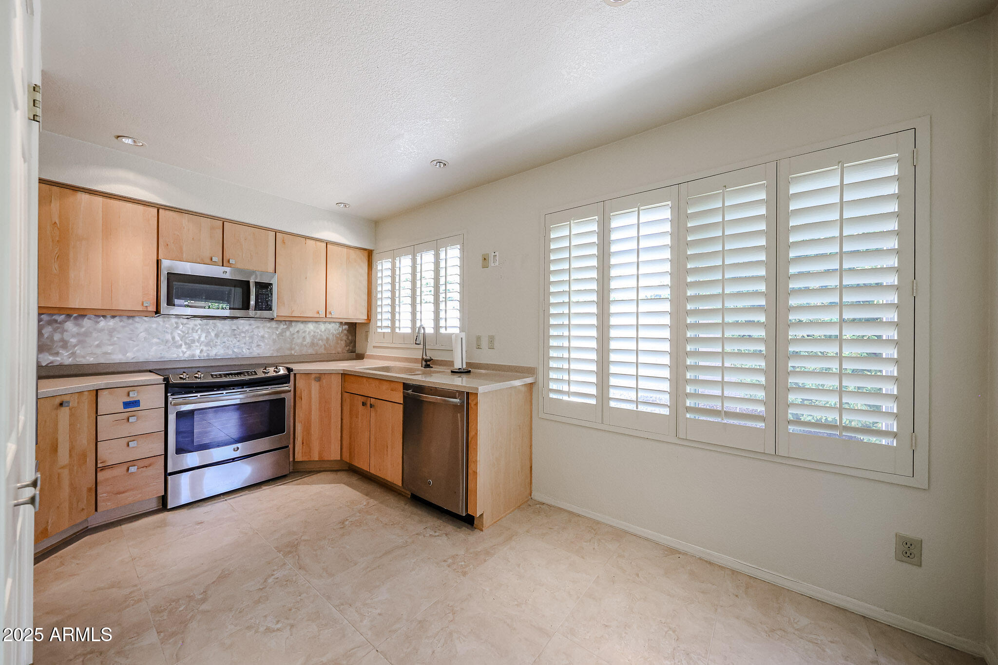 7834 East Ocotillo Road Scottsdale, AZ 85250 - Photo 4 of 47 a large kitchen with stainless steel appliances granite countertop a stove a sink and white cabinets