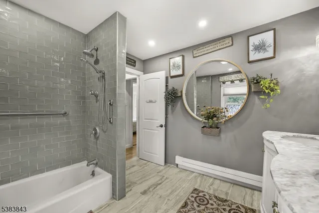 a bathroom with a tub a mirror and a shower