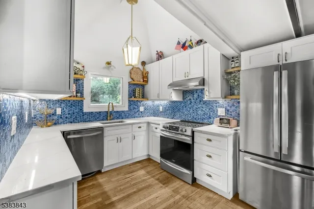 a kitchen with granite countertop a sink stainless steel appliances and cabinets