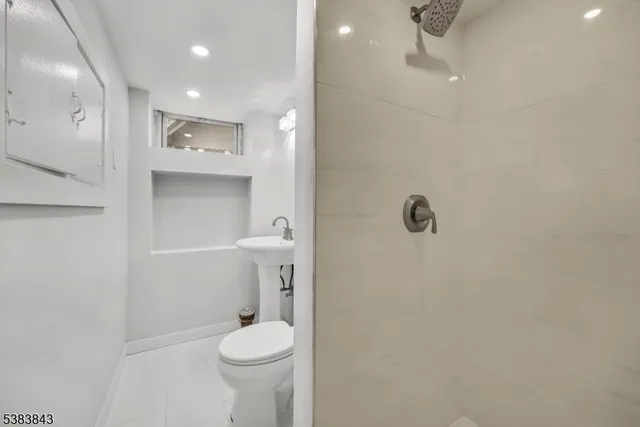 a bathroom with a toilet a sink a shower and mirror