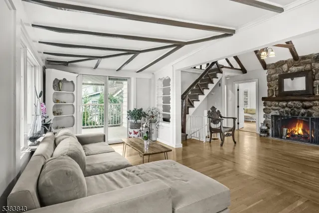 a living room with furniture a fireplace and a large window