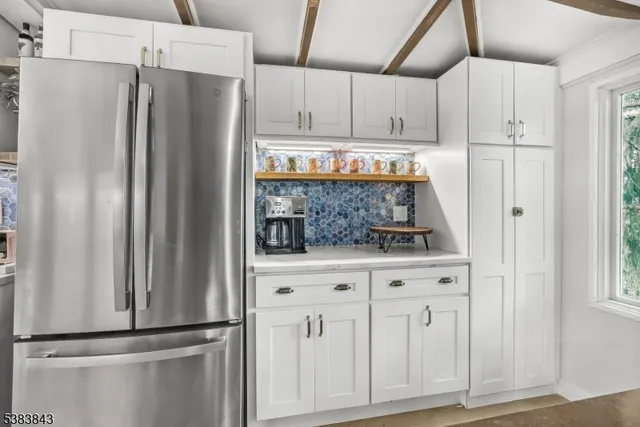 a kitchen with white cabinets and refrigerator