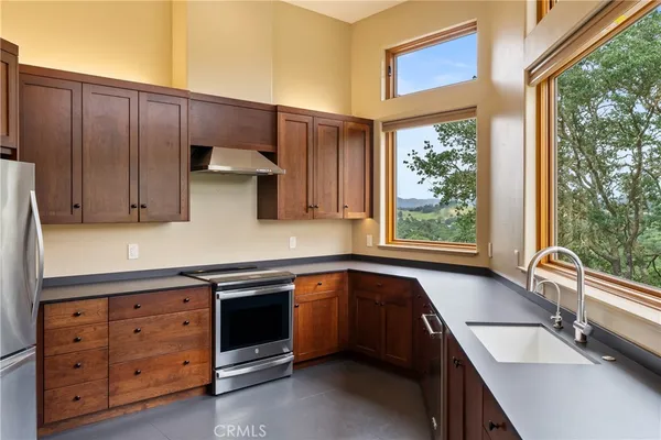 a kitchen with stainless steel appliances granite countertop a refrigerator a sink and a stove